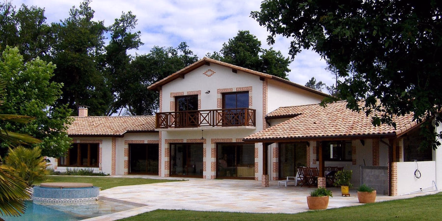 Maison R+1 de 187 m² à Lesperon avec charpente traditionnelle, menuiseries K-Line RAL 8007, tuiles Terreal vieilli Castel et enduit blanc cassé