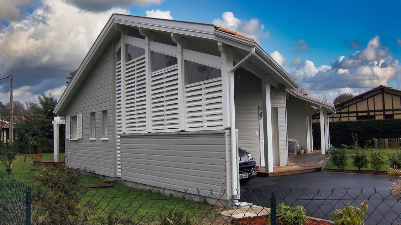 Vue latérale de maison contemporaine à Bias avec menuiseries aluminium et jardin paysager