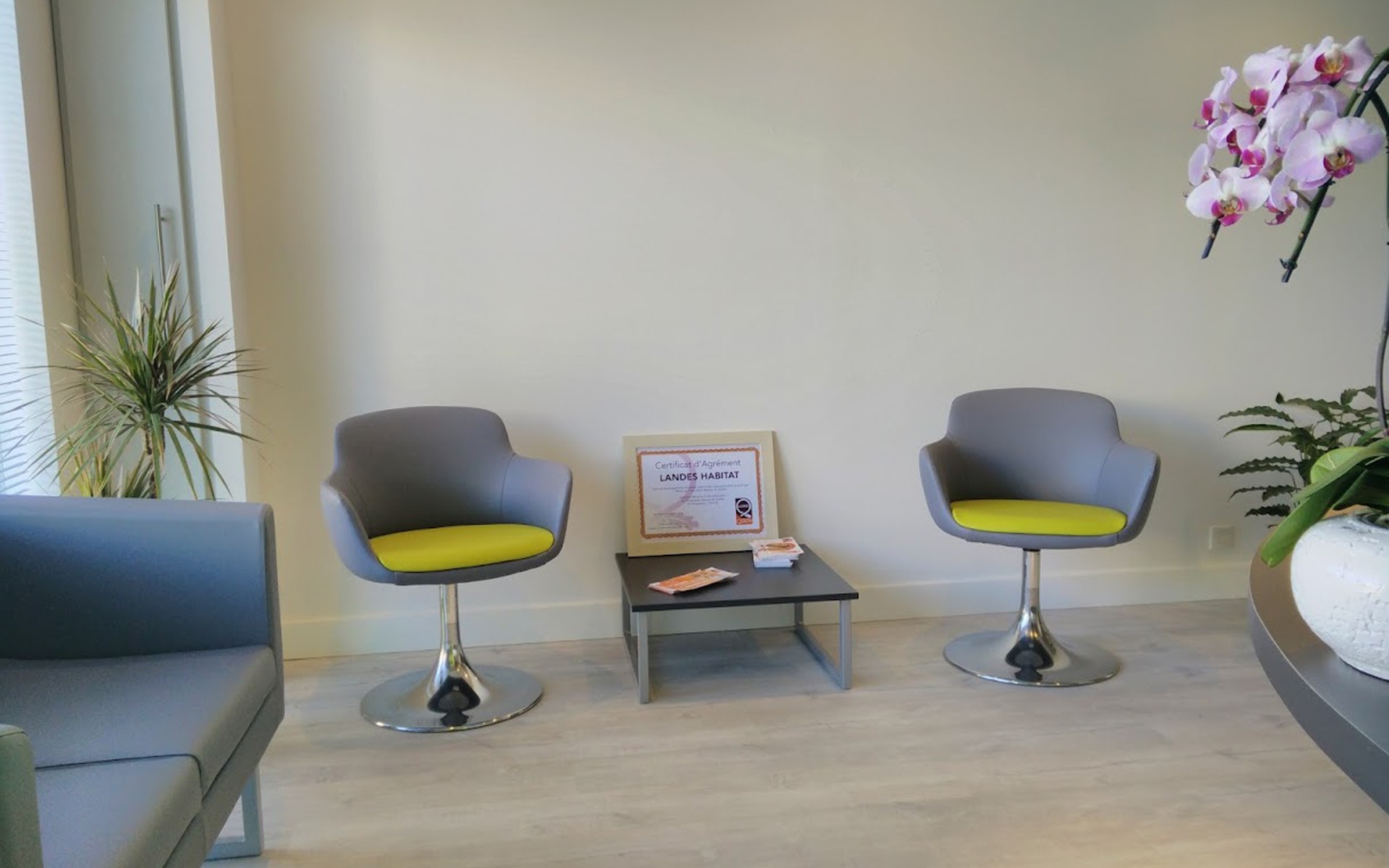 Espace d'attente de l'agence Landes Habitat à Vieux-Boucau, avec le certificat d'agrément Maisons de Qualité posé sur la table.
