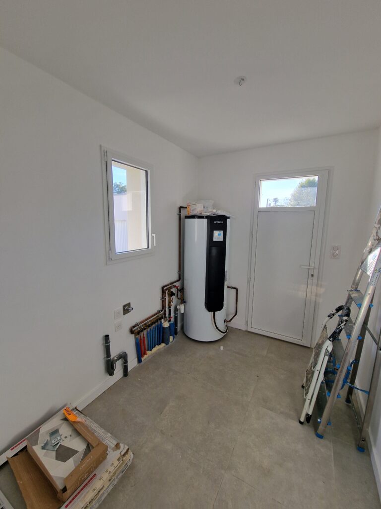 Ballon thermodynamique Hitachi Yutampo installé dans un cellier carrelé avec tableau électrique