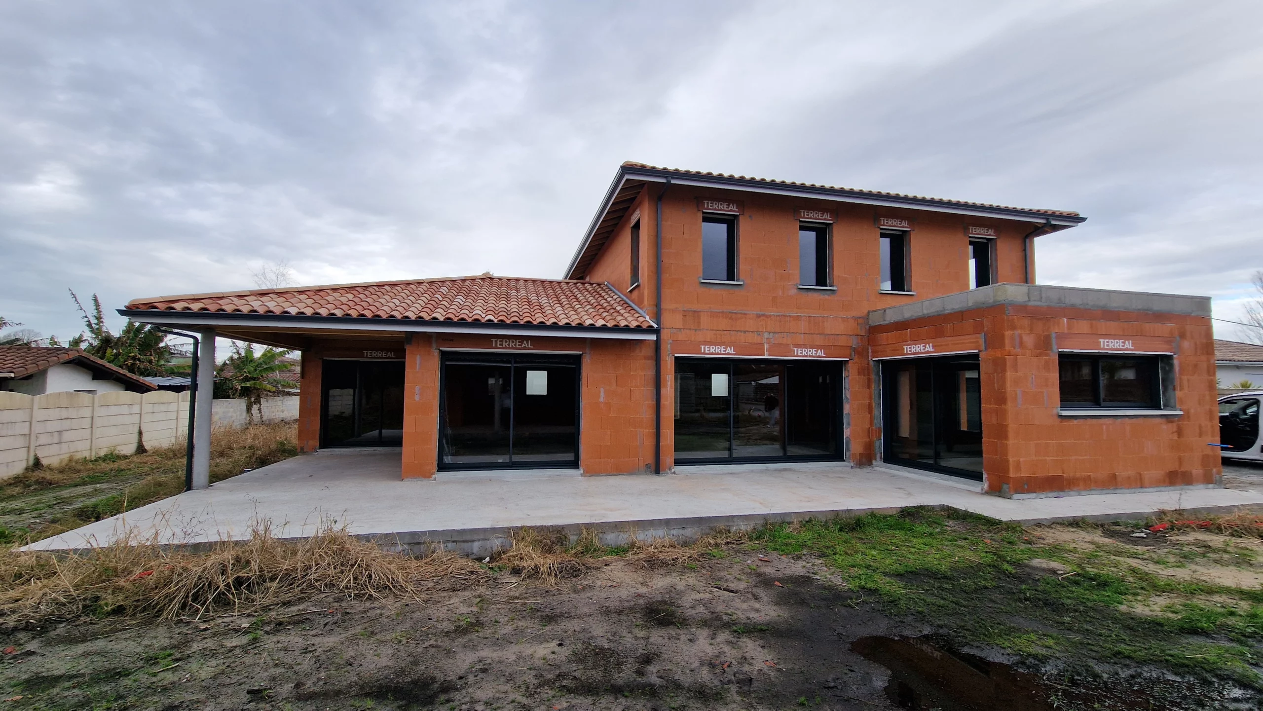 Chantier en cours : Grande Villa Familiale R+1 à Tosse (40) - Maison Landes Habitat Vue arrière d'une maison contemporaine à étage avec extension toit plat en construction à Tosse par Landes Habitat.