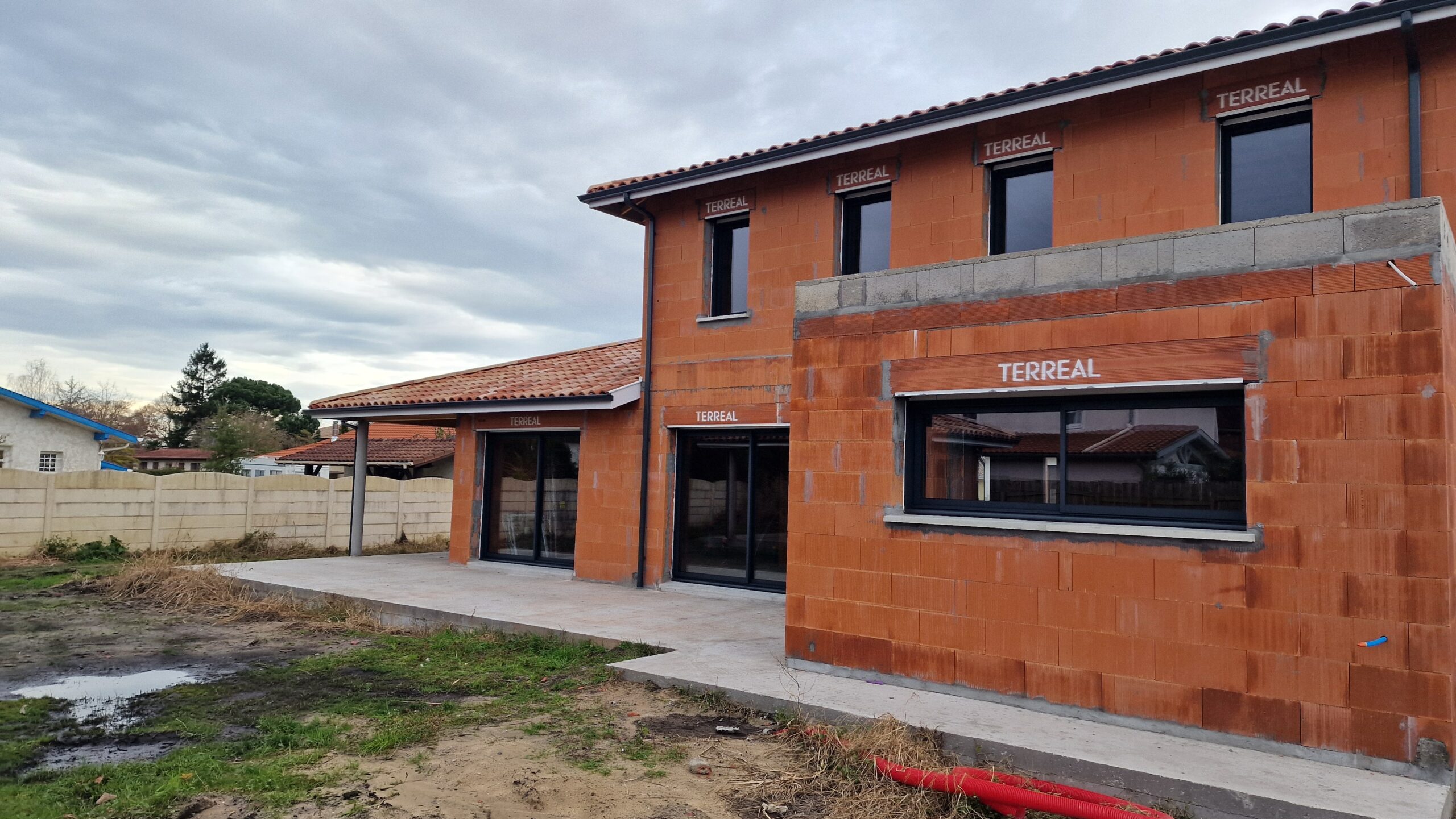 Chantier en cours : Grande Villa Familiale R+1 à Tosse (40) - Maison Landes Habitat Chantier d'une grande maison individuelle avec terrasse couverte et toit en tuiles située à Tosse