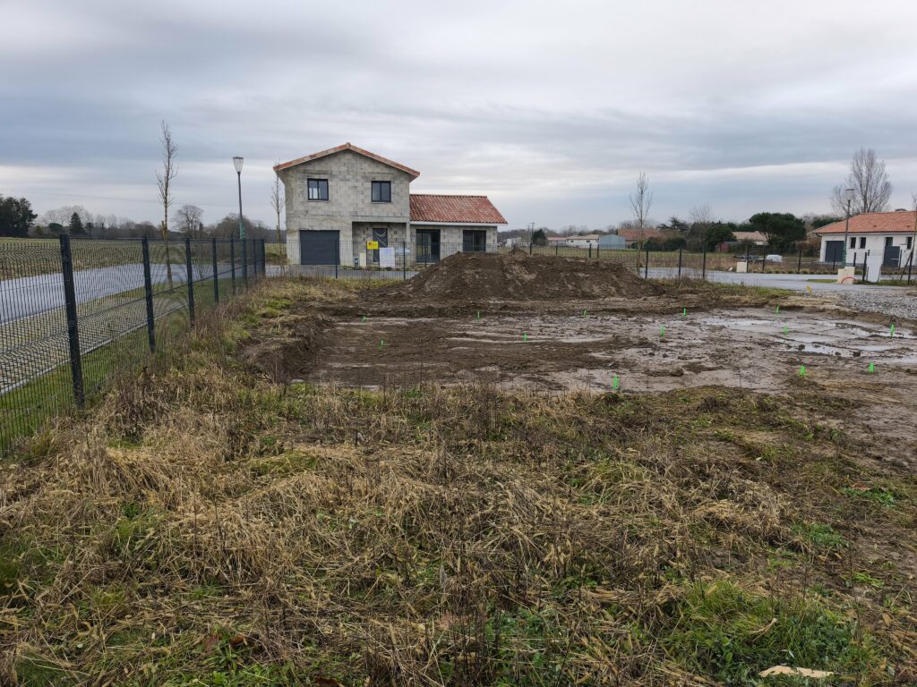 Terrain borné et préparé pour le terrassement d'une maison dans un lotissement landais