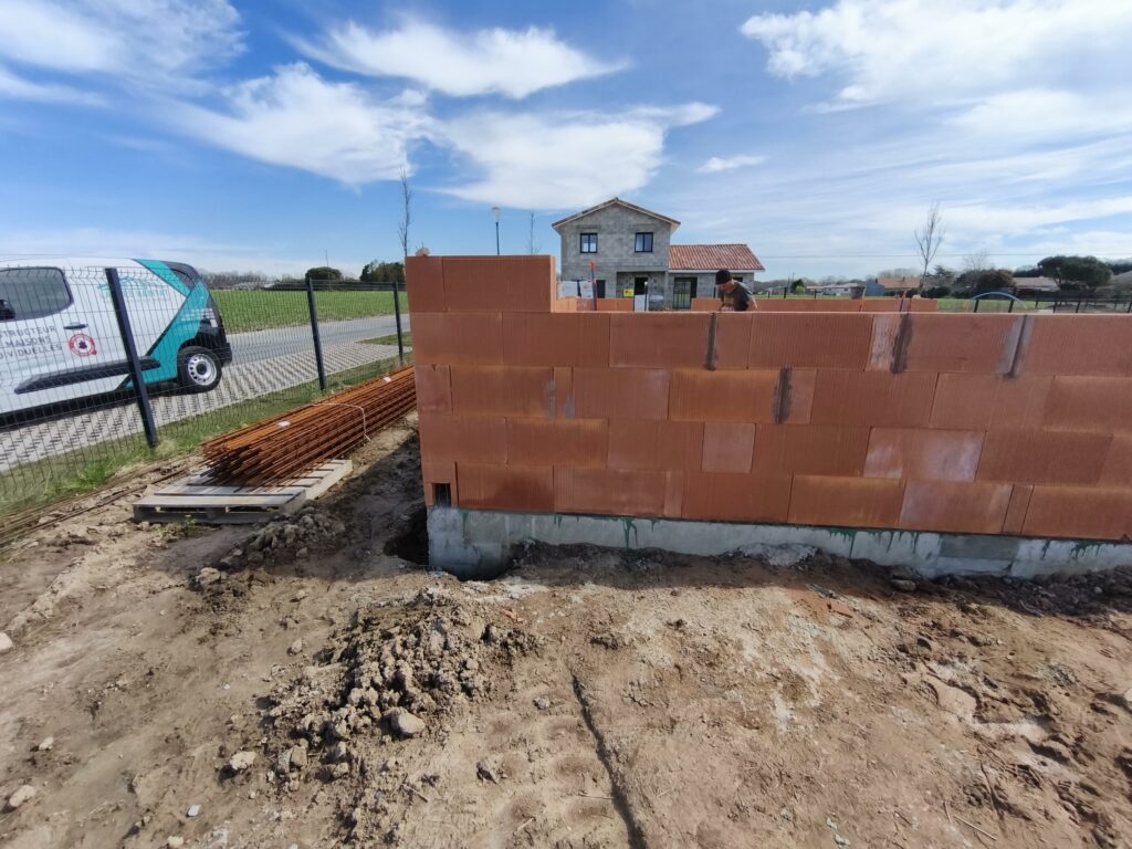 Chantier de construction d'une maison individuelle en briques rouges par Landes Habitat