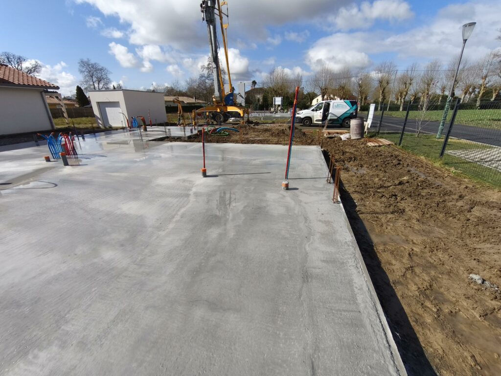 Dalle de compression en béton fraîchement coulée sur le chantier de construction à Saubrigues