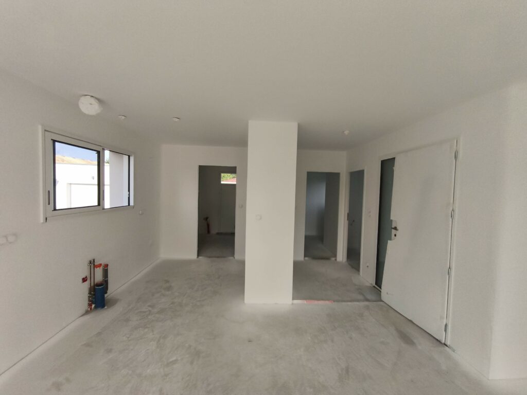 Intérieur maison neuve avec murs peints en blanc (couche d'impression) et portes posées