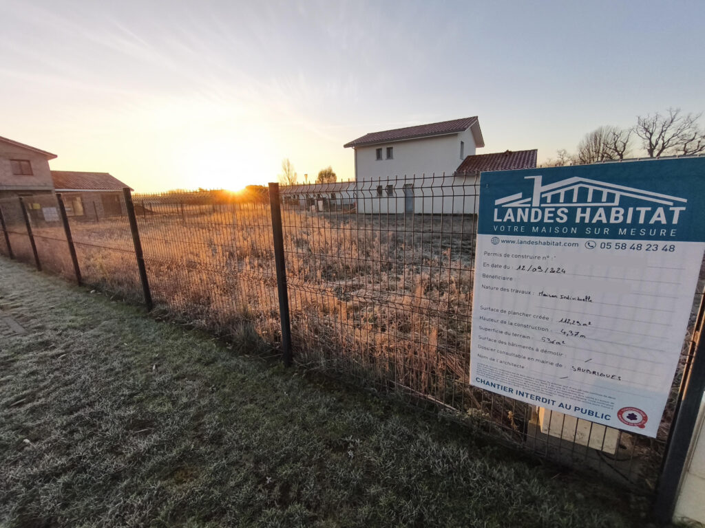 Panneau de permis de construire Landes Habitat affiché sur la clôture du chantier à Saubrigues
